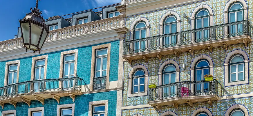 Fachadas de Lisboa decoradas con coloridos azulejos y balcones de hierro forjado.