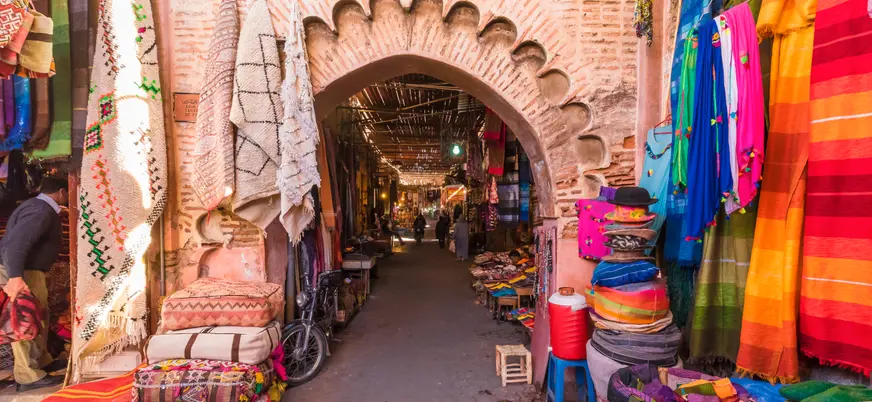 Calle comercial de la Medina de Marrakech con alfombras y puestos tradicionales