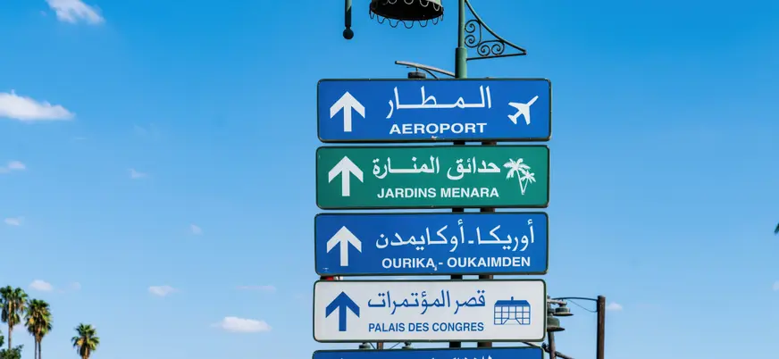Señales de tráfico hacia el aeropuerto y jardines Menara en Marrakech