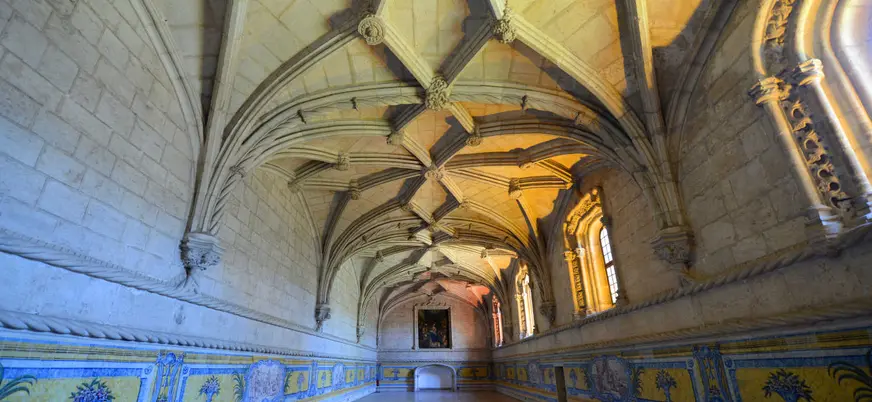 Claustro del Monasterio de los Jerónimos en Lisboa con bóvedas góticas iluminadas