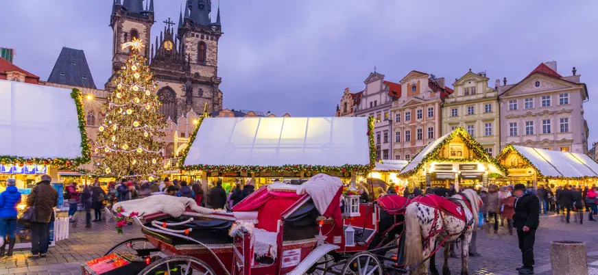 Mercado navideño en la Plaza de la Ciudad Vieja de Praga con carruaje y luces