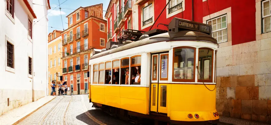Tranvía amarillo recorriendo las calles históricas del centro de Lisboa