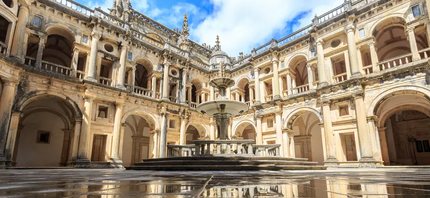 Claustro del Convento de Cristo en Tomar con fuente central y arcos renacentistas.