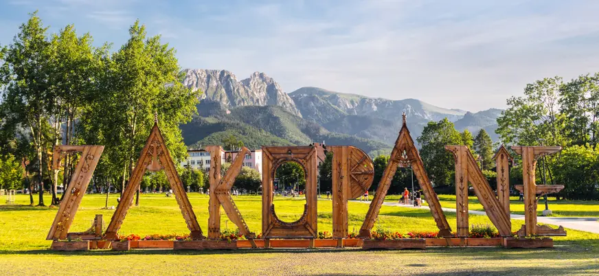Letrero de madera con el nombre Zakopane frente a los montes Tatra en Polonia