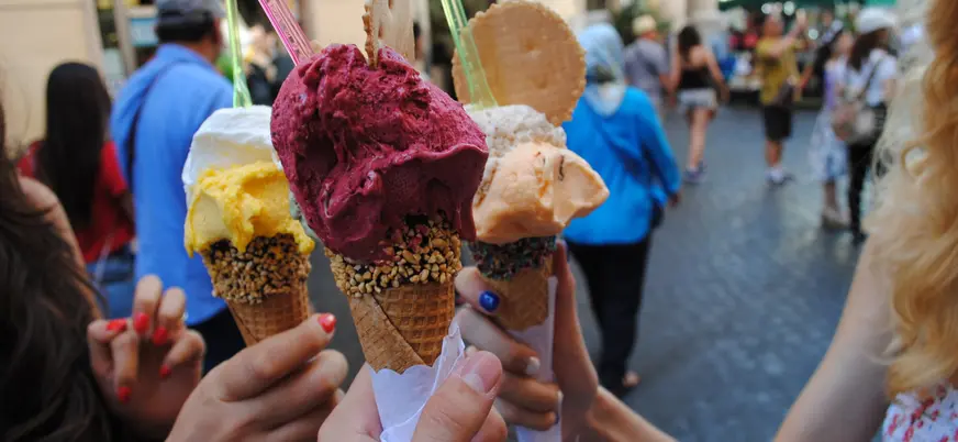 Grupo de personas disfrutando del típico helado italiano, el "gelato".