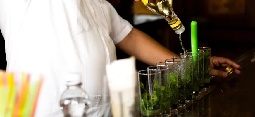 Camarero sirviendo mojitos en la ruta de bares en La Habana