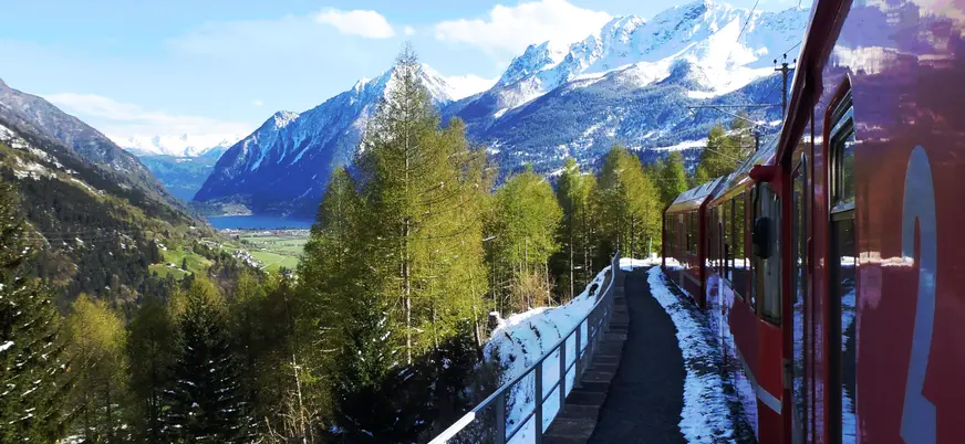 Tren Bernina pasando entre montañas y paisajes nevados de camino a Tirano.