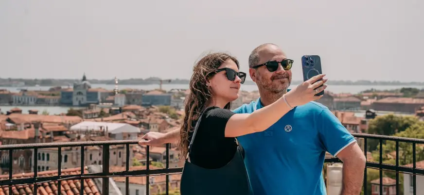 Pareja se hace una fotografía con las panorámicas de Venecia de fondo.