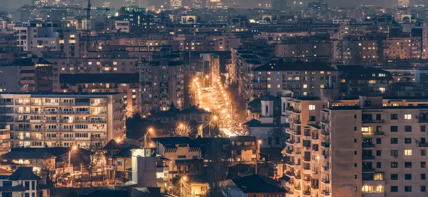 Vista aérea nocturna de Bucarest con las calles y edificios iluminados.