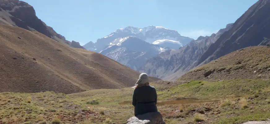 Mujer senderista observa las vistas en el Parque Aconcagua, en la excursión desde Santiago de Chile.