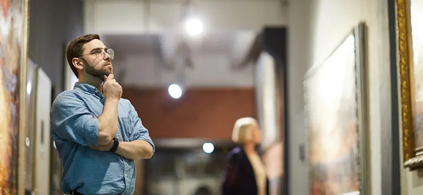 Visitante contemplando el arte que cuelga de las paredes.