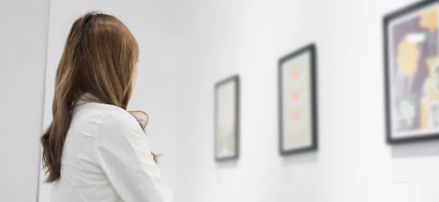 Mujer admira las obras de arte que guarda el Museo Thyssen.