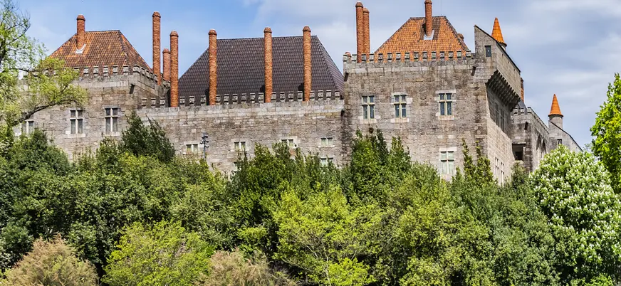 Fachada y vegetación que rodea el palacio, uno de los edificios medievales más importantes de la ciudad.