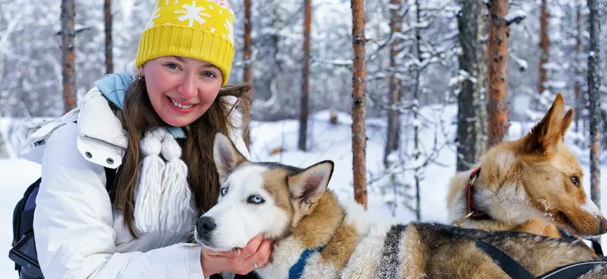 Una joven acaricia a los huskies antes de iniciar su paseo por el paraíso invernal.
