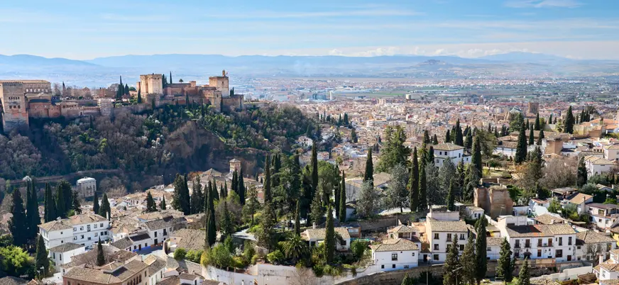 Desde las colinas del Albaicín, se divisan las casas cueva del Sacromonte, creando un paisaje único que mezcla historia y tradición.