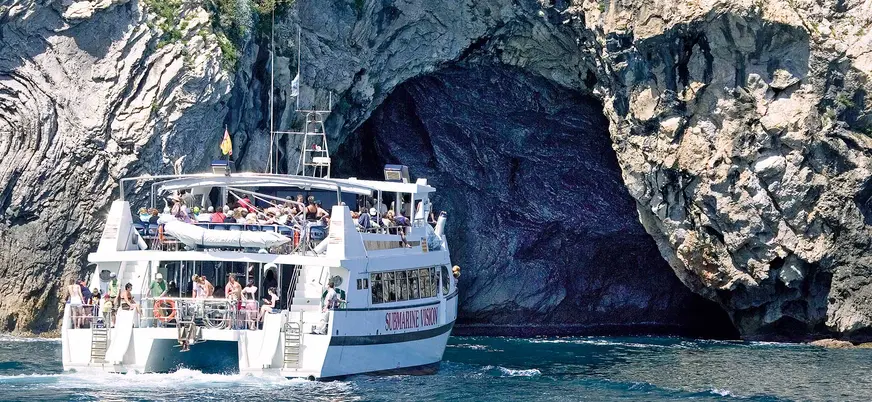 El barco avanza entre formaciones rocosas, ofreciendo una vista única del paisaje costero de la isla.