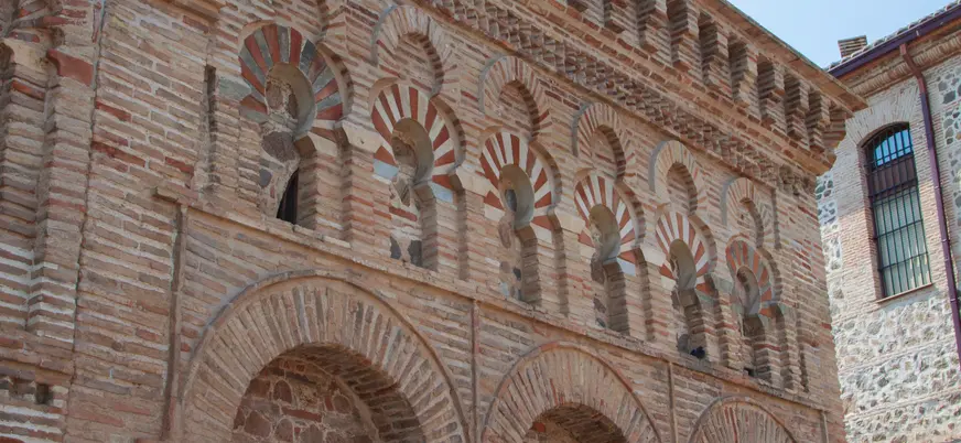 Detalle de la fachada de la Mezquita en Toledo, una estructura que combina influencias islámicas y cristianas.