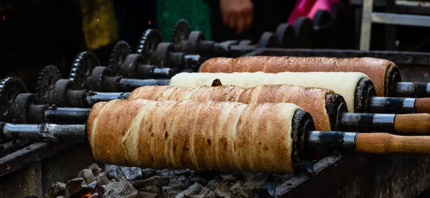 Kürtőskalács húngaro asándose al carbón en un puesto típico de Budapest