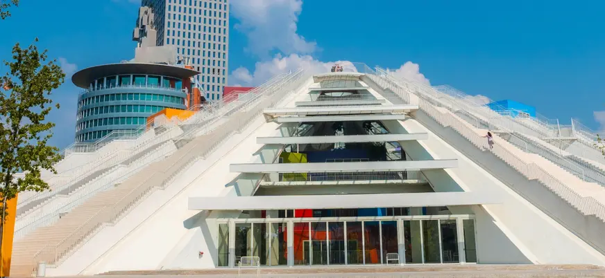 Vista de la Pirámide de Tirana, destacando su estructura inconfundible y su diseño futurista, rodeada de la ciudad.