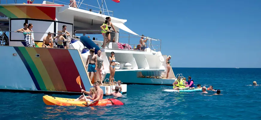 Bañistas disfrutando de un refrescante baño en el mar, con el agua clara y brillante bajo el sol.