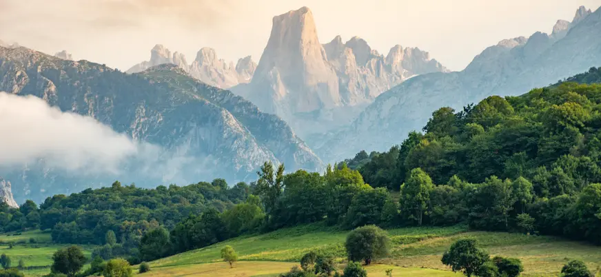 Vista del Naranjo de Bulnes entre montañas y prados verdes en Picos de Europa