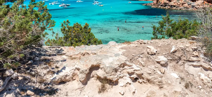 Barcos en Cala Saona en una imagen vista desde tierra firme.
