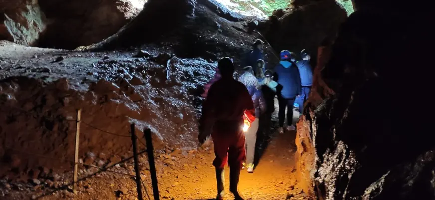 Los participantes avanzan con sus cascos de luz por el interior de la mina.