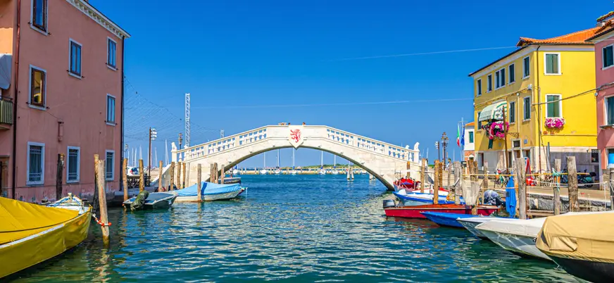 Puente blanco que forma parte del paisaje acuático de Chioggia.