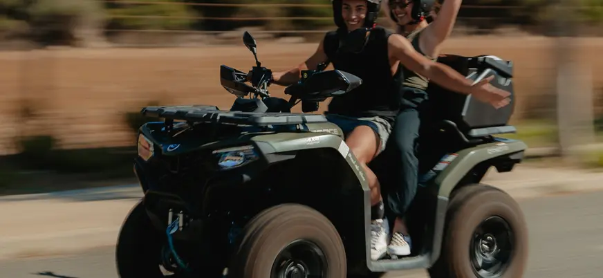 Diversión a bordo de un quad de una pareja sintiendo la adrenalina y la velocidad.