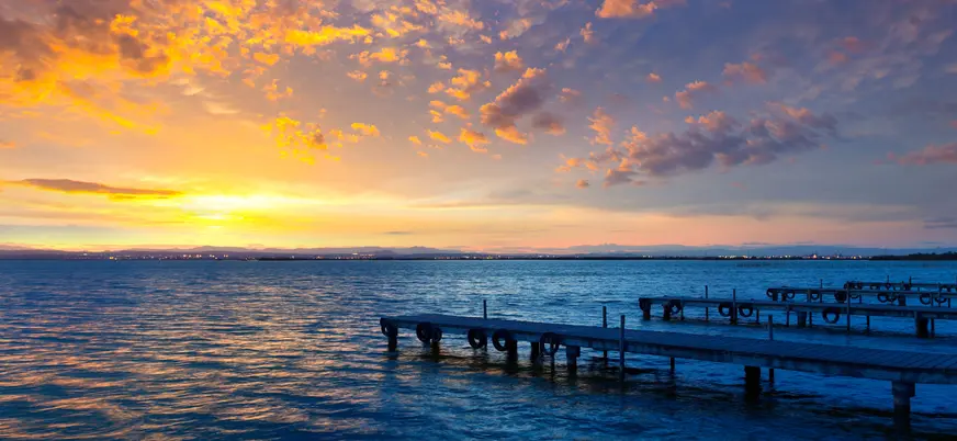 Los últimos rayos del día tiñen el agua de naranja y violeta. 