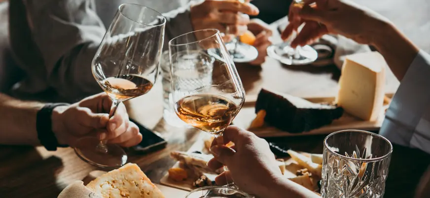 Un grupo de personas disfruta de una cara de vinos y quesos franceses en París