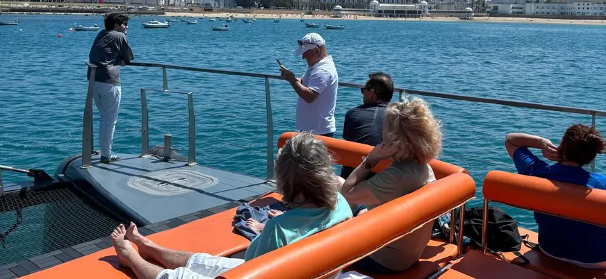Grupo de personas disfruta del sol en un catamarán en la bahía de Cádiz