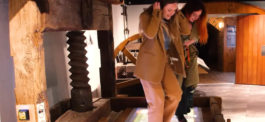 Chicas divirtiéndose en el Museo del vino de Alsacia con los pies descalzos.