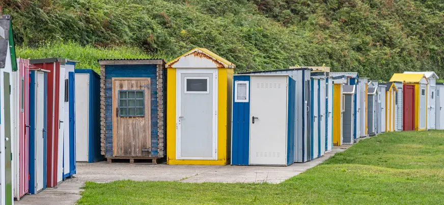 Casetas de colores para pesca alineadas en el puerto de Luarca, Asturias, junto al prado.
