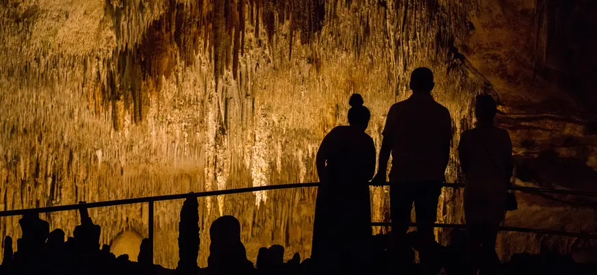 Siluetas de personas observando las Cuevas del Drach, Mallorca