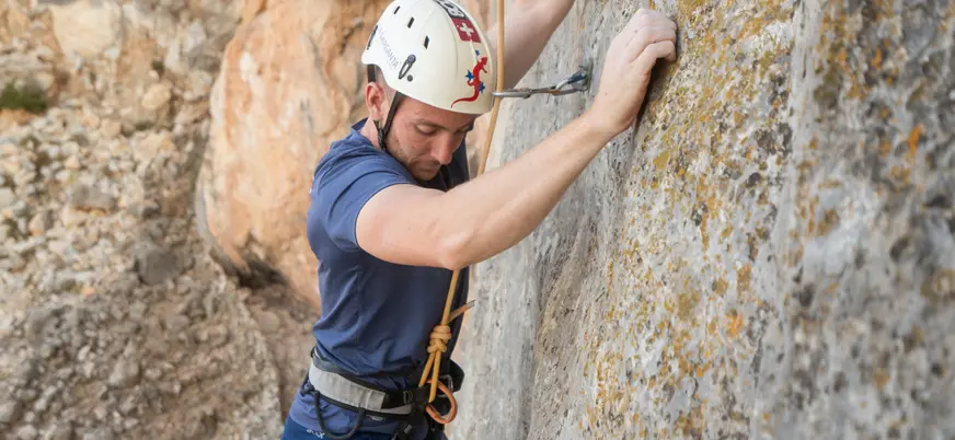 Hombre escalando una pared de roca en El Chorro, cerca del Caminito del Rey