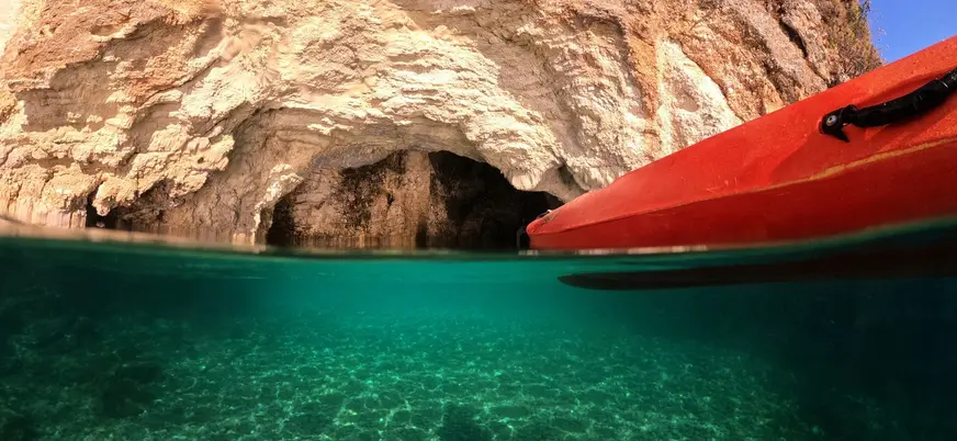 Kayak frente a cueva marina en Es Canutells, Menorca