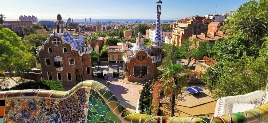 Vista panorámica del Parque Güell con mosaicos coloridos y casas diseñadas por Gaudí