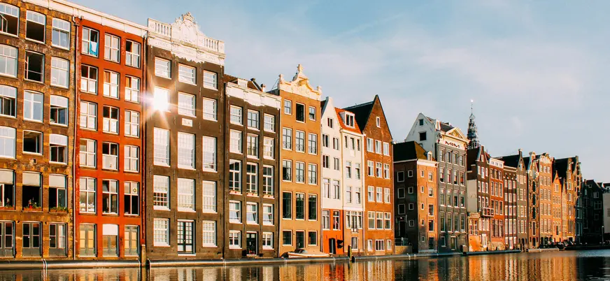 Casas típicas reflejadas en los canales de Ámsterdam al atardecer