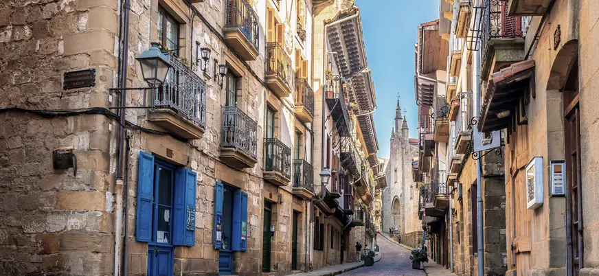 Calle histórica con fachadas de piedra y balcones en Hondarribia.