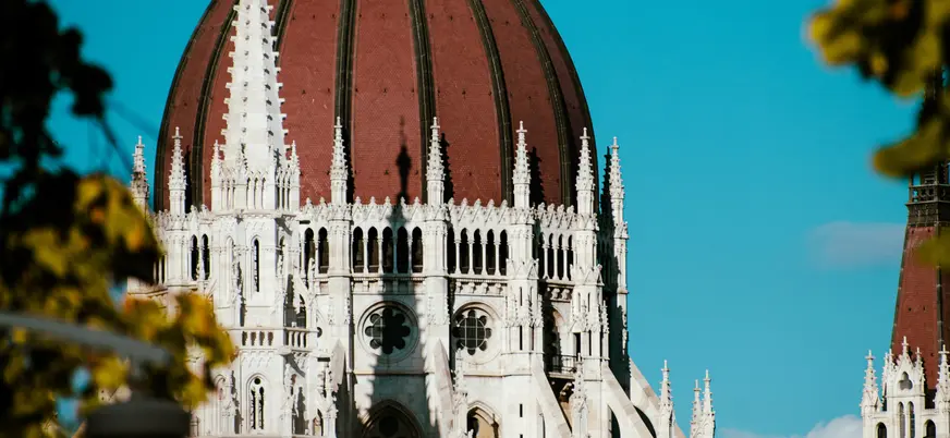 Primer plano de la cúpula neogótica del Parlamento de Budapest contra el cielo.