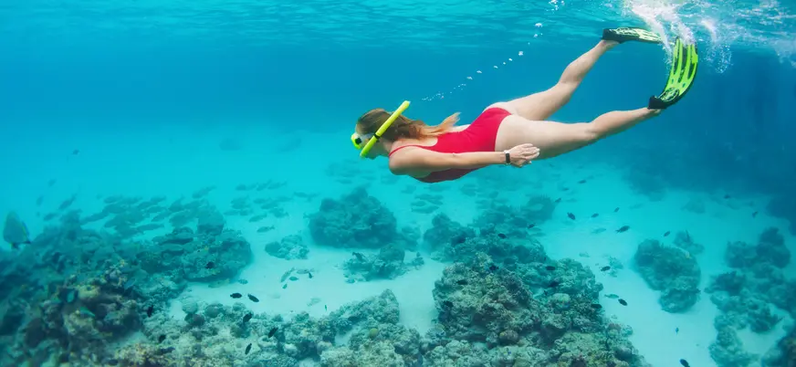Mujer haciendo snorkel en las aguas de Mallorca entre arrecifes