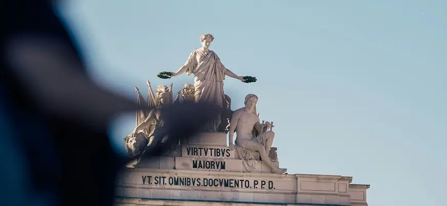 Esculturas del Arco de Rua Augusta en Lisboa bajo cielo despejado
