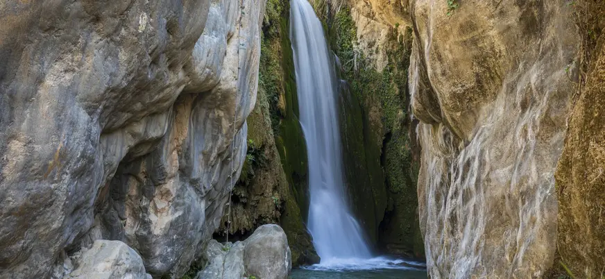 Cascada natural de agua cristalina fluyendo entre rocas. Ideal para senderismo, ecoturismo y viajes de aventura.