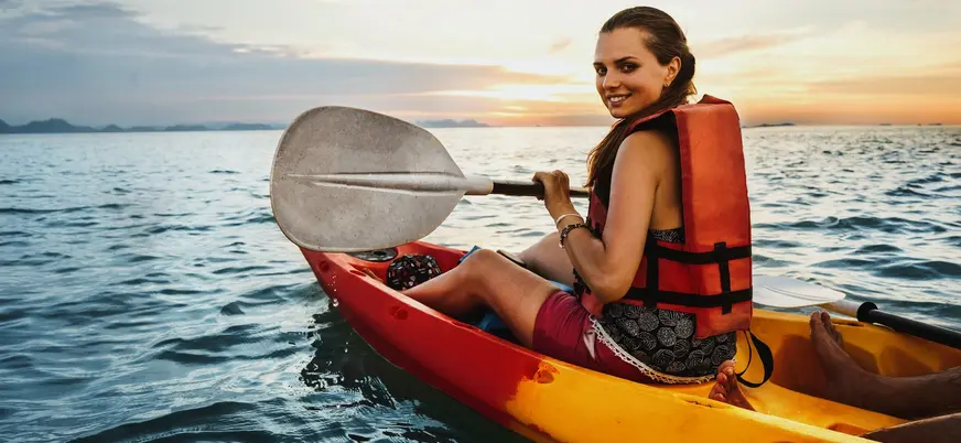 Mujer en kayak durante el atardecer en Es Grau, Menorca