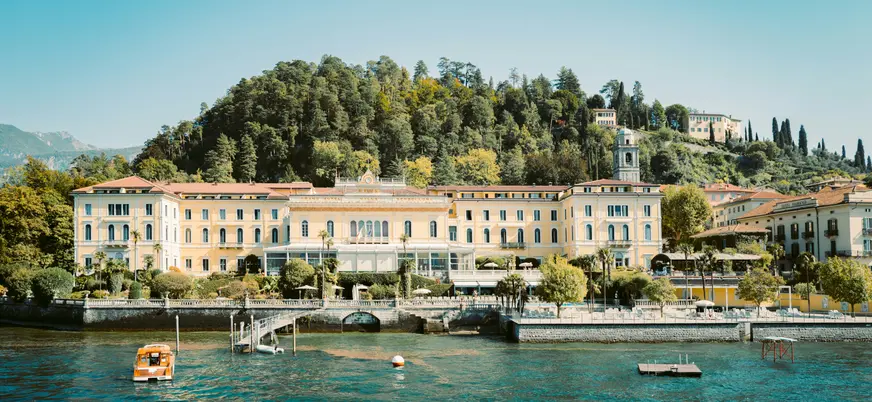 Fachada del Grand Hotel en el Lago di Como frente al agua y colinas boscosas