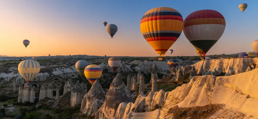 Globos aerostáticos sobre chimeneas de hadas en Capadocia al amanecer, Turquía