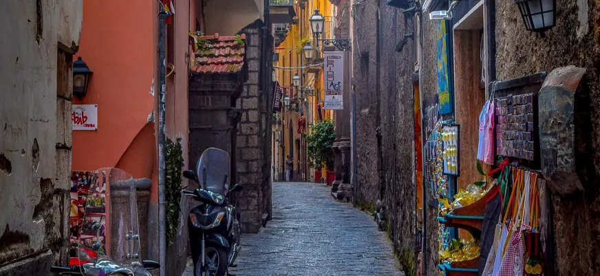 Vista de una callejuela estrecha de Sorrento, con pequeños negocios y tiendas de recuerdos.