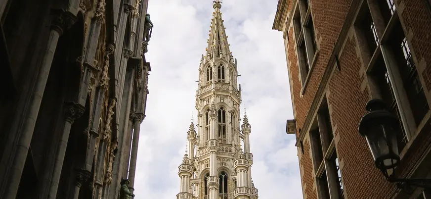 Aguja gótica del Ayuntamiento de Bruselas, Bélgica, vista entre edificios del casco antiguo de la Grand Place.