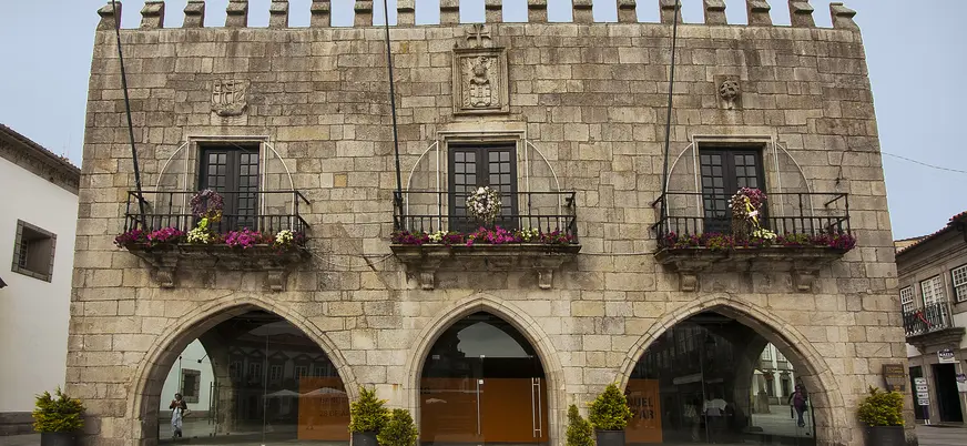 Fachada del antiguo ayuntamiento de Viana do Castelo con arcos y balcones floridos.